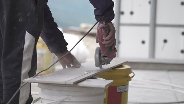 HD30 SLOWMOTION Close up of labourer cutting tile with grinder