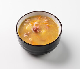 Pea soup with smoked ham in black bowl on white isolated. Healthy homemade  food.
