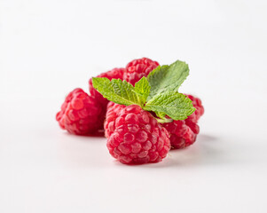 Juicy forest raspberry with mint leaf on a white isolated background.