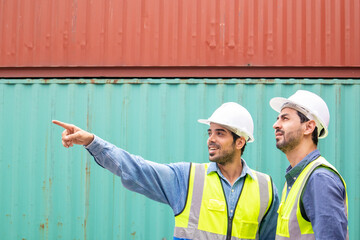 A professional engineer discussing work with a colleague in a container shipping company that is...