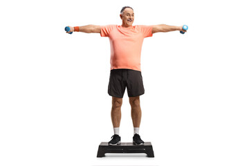 Full length portrait of a mature man exercising step aerobic and holding weights