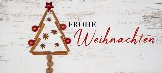 Weihnachten Hintergrund Grußkarte - Christbaum aus Weihnachtsornamenten, Stern, Zimtstangen, Walnüssen, Christbaumkugeln und Sternanis, auf weißem rustikalem Tisch aus Holz, Draufsicht © Corri Seizinger