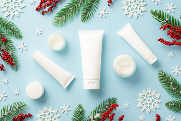 Winter season skin care concept. Top view photo of white tubes without label cream jars pine...