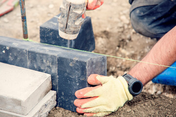 Footpath under construction. Builder installing new kerbs on concrete close-up