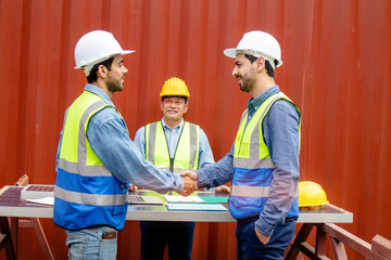 Smart engineers in safety helmets and uniforms with having handshaking for teamwork, collaboration concept