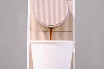 Capsule coffee machine and paper cup close-up on gray background.