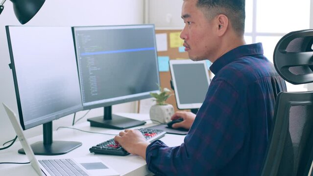 Young Asian man, developer programmer, software engineer, IT support, working on computer to check coding in bugging system
