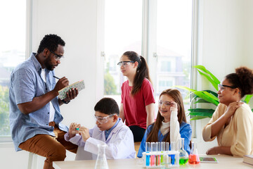 group of male and female students Studying with an African science teacher in an interactive discussion class