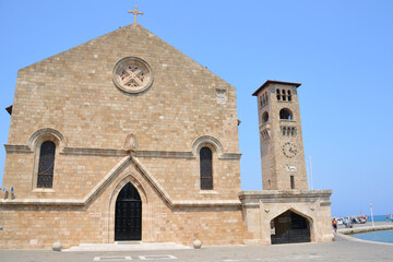 ancient monastery with ancient tower and clock on the waterfront of greek island Rhodes