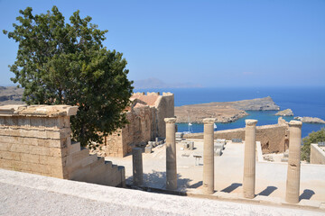 part of ancient acropolis Lindos with green tree and seaview on greek island Rhodes