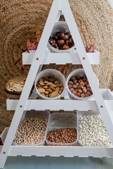 Homemade autumn/winter pantry with legumes and nuts. Shelf with beans, chickpeas, almonds,...