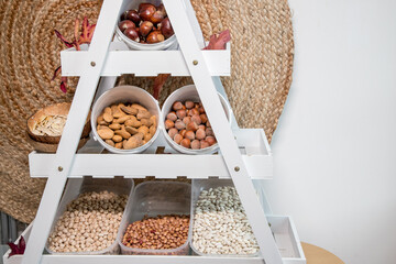 Homemade autumn/winter pantry with legumes and nuts. Shelf with beans, chickpeas, almonds,...