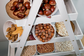 Homemade autumn/winter pantry with legumes and nuts. Shelf with beans, chickpeas, almonds,...