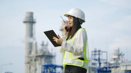 Industrial engineer using digital tablet for work against the background of electrical power plant.