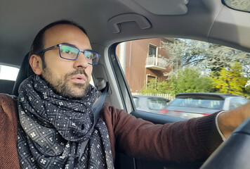 Uomo alla guida della propria automobile nel traffico della città