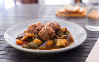 cooked meatballs with stewed eggplant with haze in bowl