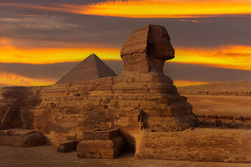 Fototapeta na wymiar Sculpture of the Sphinx against the background of the Priamis of Cheops on the Giza plateau in Egypt against the background of the picturesque sky