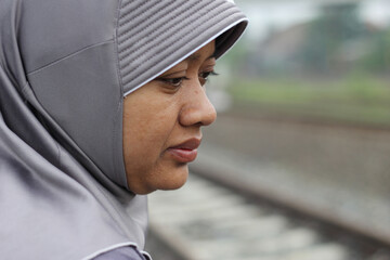 Close up photo of Muslim woman wearing hijab purposely blurred background with space for text. Selective focus.