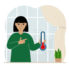 A woman near the window with a device for measuring the temperature in the room.