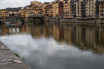 Fototapeta na wymiar Bridge over the river Arno. Bank of the river Arno in Florence, Italy. Reflection. 