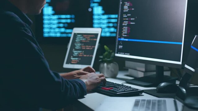 Young Asian man, developer programmer, software engineer, IT support, working hard at night overtime on computer to check coding in bugging system