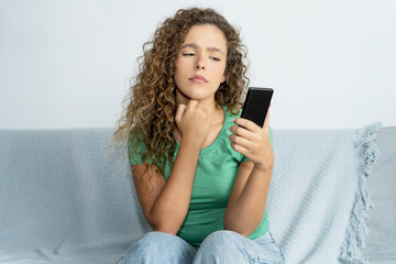 Beautiful young adult woman with phone waiting for message from boyfriend