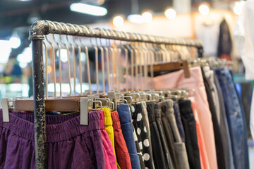 Colorful clothes on clothing rack in fashion store.