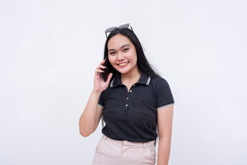 A young asian woman in a black polo shirt holding a cellphone. Calling or talking to someone on the...