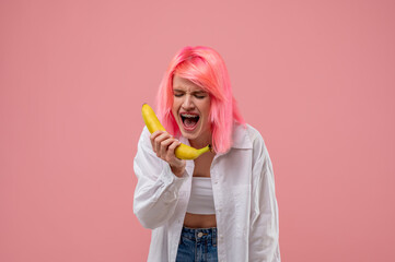 Pink-haired girl singing into the banana mic