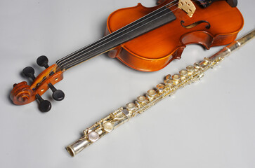 Fototapeta na wymiar Violin and silver flute on a light background.