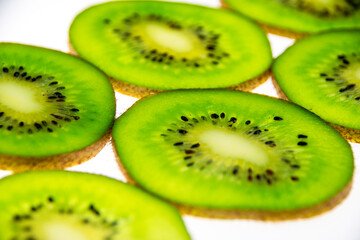 A pattern of fresh kiwi slices on a white background.