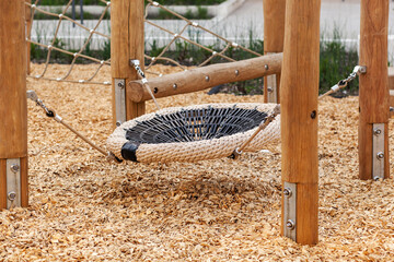 Playground with Modern Swing Nest from Robinia Timber with Natural Ground Cover Sawdust. Modern...