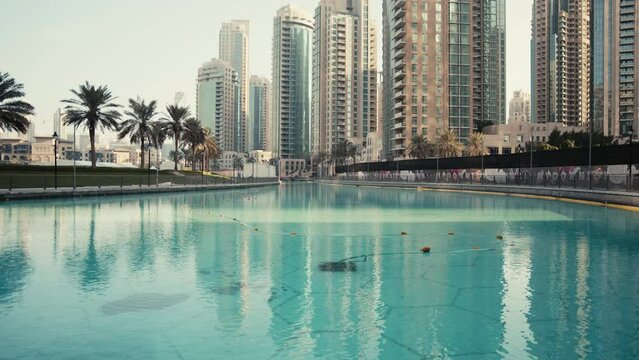 Automated swimming pool vacuum cleaner cleaning the bottom of the pond in downtown of Dubai city near the Burj Khalifa, removing debris and algae.