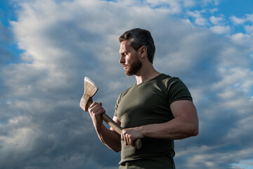 man with axe. lumberman man hold ax. brutal man on dramatic sky background