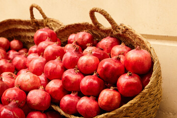 Pomegranate fruits in basket. Heap of fresh pomegranates