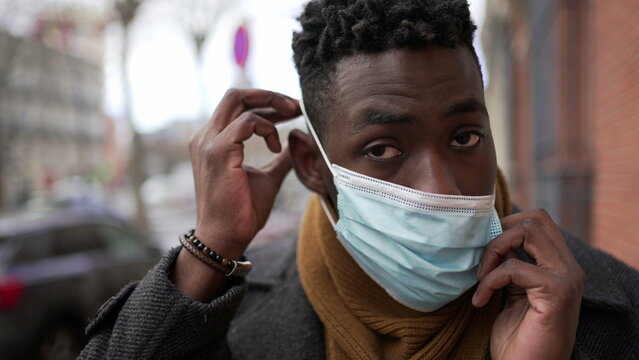 Black Man Putting Covid Face Mask While Walking In City Outside In The Cold Winter Season2