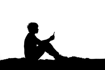 Silhouette of a lonely man, despair, heartbroken, looking at his mobile phone