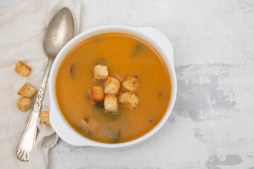 vegetable soup with crackers in white bowl on ceramic