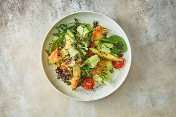 Salad with avocado and salmon in a plate. Close-up, selective focus