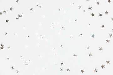 Silver sparkle confetti stars isolated on white background. Glitter, shine, bright. Christmas festive flat lay, winter holiday, new year, happy birthday concept. Flat lay, top view, copy space.