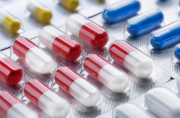 Pile of medical pills in white and red colors. Tablets in plastic packaging. The concept of...