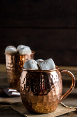 The dessert food vintage style : The Marshmallow with hot chocolate in copper cup on the wooden table. Background copy space for copy text