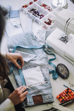 High angle view of design professional measuring back pocket of jeans at workshop