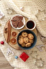 Various Christmas decorations, cup of tea or coffee, sweets, small presents, knitted blanket and candles. Flat lay.