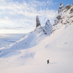 Old Man of Storr in the snow, Isle Of Skye.  Person hiking in snow up mountain
