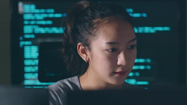 Young Asian woman, developer programmer, software engineer, IT support, working hard at night overtime on computer to check coding in bugging system and running program successful.