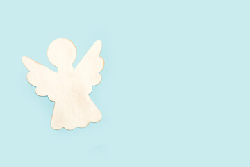 Fototapeta premium Angel de madera de color blanco sobre un fondo celeste pastel liso y aislado. Vista superior y de cerca. Copy space