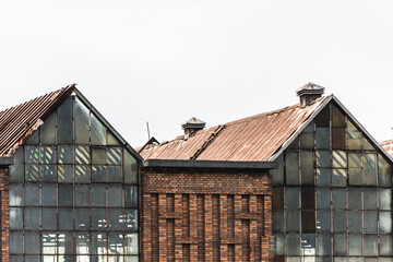Old factory in an industrial area with broken windows glass and with missing roof tiles