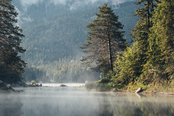 Beautiful misty morning on Eibsee, Oberammergau.  Bavaria, Germany.  Zugspitze Mountain in background 