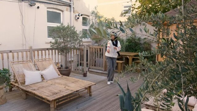 Smiling women wearing hijabs meeting on patio